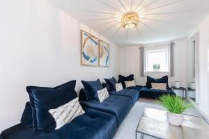 a living room with a blue couch and a table at Stunning 4 Bed 3 Bathroom Home in Gloucestershire