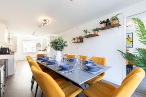 a dining room with a table and yellow chairs at Stunning 4 Bed 3 Bathroom Home in Gloucestershire +21 photos