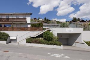 a white building with stairs and a garage at Feriensiedlung Trü 17 in Scuol
