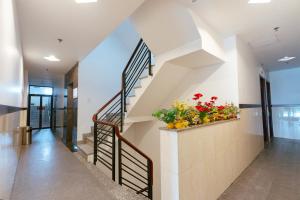 a staircase in a house with a vase of flowers at Belvilla Near Quang Trung Exhibition Center District 12 Formerly Southern Star Hotel in Ho Chi Minh City