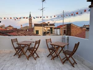 a patio with two tables and chairs on a roof at CASA LILLY camere matrimoniali con bagno privato in Chioggia