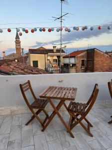 a wooden table and two chairs on a roof at CASA LILLY camere matrimoniali con bagno privato in Chioggia