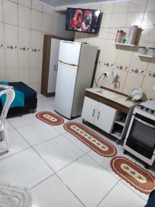 a kitchen with a refrigerator and a stove at Kitnet in Araucária