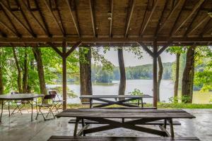 two picnic tables with a view of a lake at Letchworth Valley Campground Cabins in Bliss
