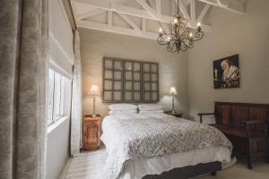 a bedroom with a large bed and a chandelier at Maryah House in Pretoria