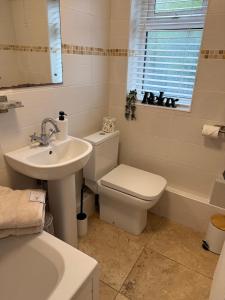 een badkamer met toilet, wastafel en bad bij Crosskeys Cottage in Crosskeys