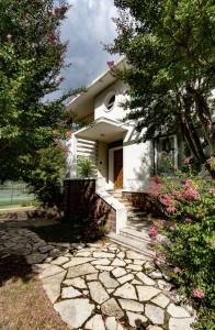 a white house with a stone walkway in front of it at Chambre 4 Rouge - WIFI - Proche gare in Labouheyre