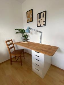 a desk with a lamp and a chair in a room at Lichtblick in Radebeul