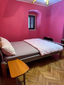 a pink bedroom with a bed and a chair at Villa#12 in Savina