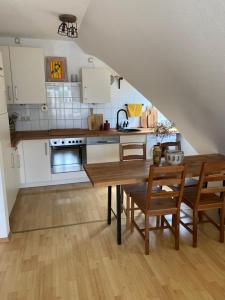 a kitchen with white cabinets and a wooden table at Lichtblick in Radebeul