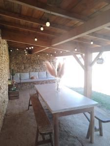 a table and chairs in a room with a bench at Les Gîtes de la Roche Élie in Rom