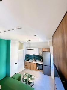 a kitchen with a green couch and a refrigerator at Tirana Essence Apartment in Tirana