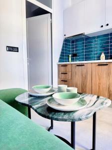 a table with bowls and plates on it in a kitchen at Tirana Essence Apartment in Tirana