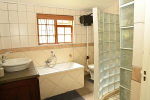 un bagno con lavandino, vasca e WC di Concordia Kloof Cottage a Baardskeerdersbos