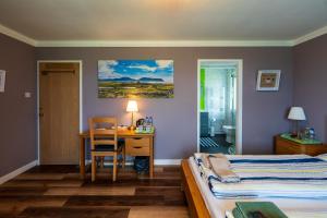 a bedroom with a bed and a desk and a table at Orkney Bed & Whisky in Orphir