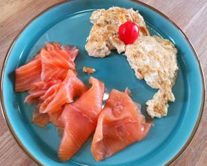 a blue plate with salmon and a cherry on top at Orkney Bed & Whisky in Orphir