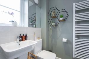 a bathroom with a sink and a toilet and a mirror at Peaceful Two Bedroom Two Bathroom Home in Gloucestershire