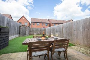a wooden table with two chairs and wine glasses at Peaceful Two Bedroom Two Bathroom Home in Gloucestershire