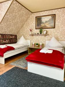 a bedroom with two beds and a red blanket at Haus ZUR PINGE in Kurort Altenberg +81 photos