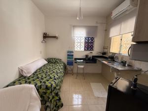 a small room with a bed and a kitchen at Casa mobiliada de 1 quarto na R Oliveira Alves Fontes, 597 - 597 A - Jardim Gonzaga in Juazeiro do Norte