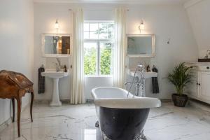 a bathroom with a large tub and two sinks at Manor House By Lake Mälaren Near Stockholm in Ekolsund +32 photos