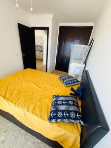 サンミゲル・デ・アボナにあるPromenade Paradise Apartmentの黄色い毛布が掛けられた大きなベッドのある寝室