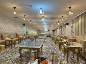 a restaurant with tables and couches and chairs at Diouf Al-Mquam Al-Masy Hotel shuttle service to the Haram in Mecca