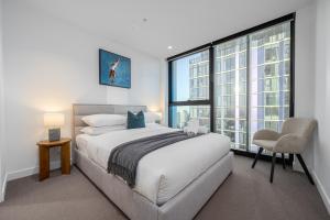 a bedroom with a bed and a large window at Luxe 3BR Skyline Sunset Residence Level 63 - CBD Views, Parking, Pool, Sauna, Gym in Melbourne
