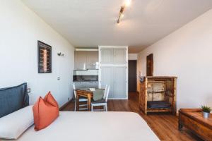 a bedroom with a bed and a table and a kitchen at Studiò Pila 1800 in Pila