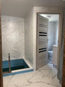 a bathroom with a tub and a toilet in it at Гія в Баню in Mizhhirya