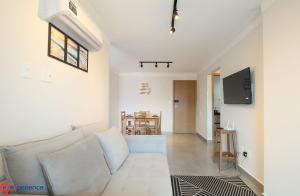 Vila BalneáriaにあるBeira Marの白いソファとテレビのあるリビングルーム