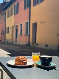 a table with two plates of food and a glass of orange juice at Hotel Locanda Castagnola in Lugano