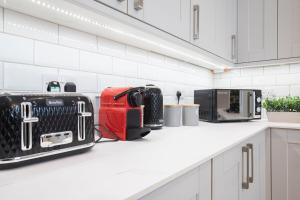 a kitchen with luggage on a white counter top at Stunning 5 Bed Regency Home in Gloucestershire +39 photos