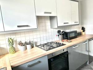 a kitchen with white cabinets and a stove top oven at Jeremiah Lodge in Fallings Park