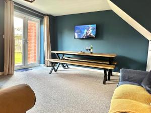 a dining room with a bench and a tv on the wall at Jeremiah Lodge in Fallings Park