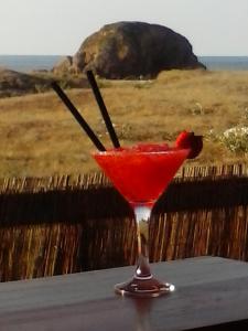 una bebida roja en un vaso de martini sentado en una mesa en Hostal Restaurante Parajes, en Castropol