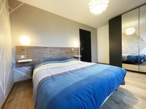 a bedroom with a large blue bed in a room at appartement cosy in Le Thillot