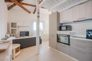 a kitchen with white cabinets and a living room at Ca' Serena - Murano centro - 10 min from Venice in Venice