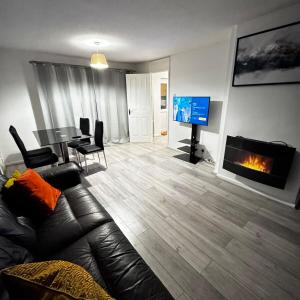 Slades GreenにあるModern 3BR House with Free Parkingのソファと暖炉のあるリビングルーム