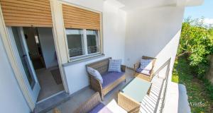 a balcony with two chairs and a glass table at Holiday Home Leo in Mostar