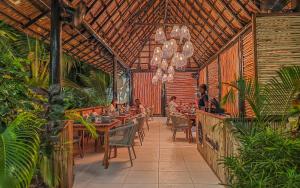ein Restaurant mit Gästen, die an Tischen auf einer Terrasse sitzen in der Unterkunft Z Hotel & Z2 Hotel in Nungwi