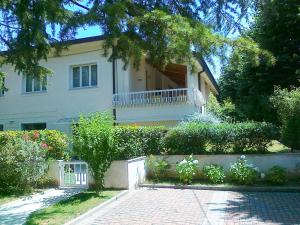 Una gran casa blanca con balcón frente a ella en Residenza Alice - Toscana mare e monti, en Camaiore