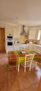 a kitchen with a table with a colorful rug on it at spacious villa in Saint-Vivien-de-Médoc