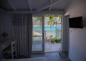 a bedroom with a balcony with a view of a pool at Steven in Vasiliki