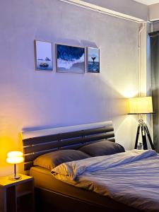 a bedroom with a bed with a lamp and pictures on the wall at Mango Rooms & Rooftop in Bangkok