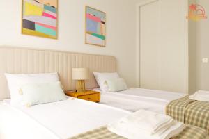 Un dormitorio con dos camas y una lámpara en una mesita de noche. en Casa de la Costa - Pintor Clemente, en Santiago de la Ribera 13 fotos más