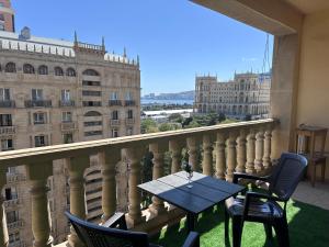 - Balcón con mesa, sillas y edificios en Luxury Sea View apartment by Bakuapart, en Baku
