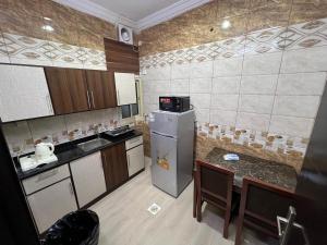 a small kitchen with a refrigerator and a table at وجهة أبحر in Jeddah