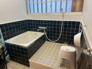 a bathroom with a bath tub and a toilet at 釜炒り茶の宿陽だまりTraditional Japanese house near Kumano Kodo and Nachi Falls with parking bikes garden and onsite tea house in Nachikatsuura +53 photos