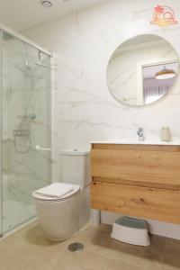 y baño con aseo, ducha y espejo. en Casa de la Costa - Pintor Clemente, en Santiago de la Ribera